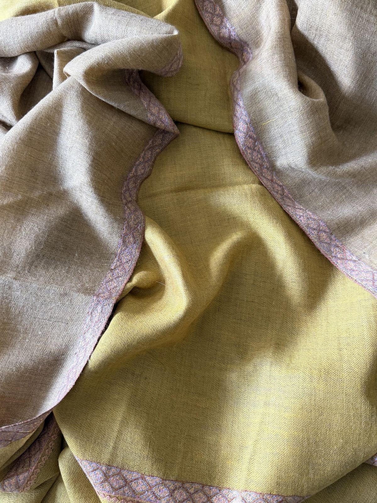 Close-up showing the mustard yellow face and taupe face of the two-sided pashmina with lilac Sozni border