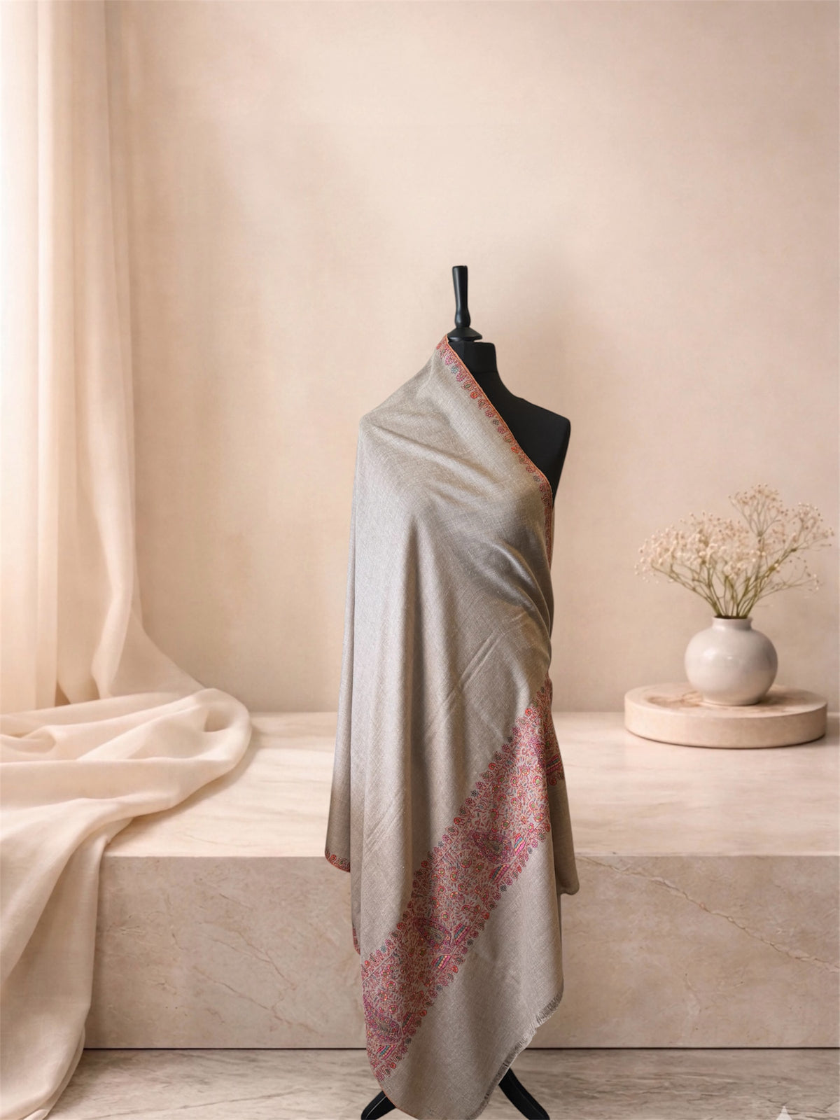 Natural beige pashmina shawl with pink multicolour Sozni border draped on a mannequin, side view