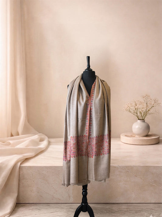 Natural beige pashmina shawl with pink paisley end bands worn over the shoulders, front view