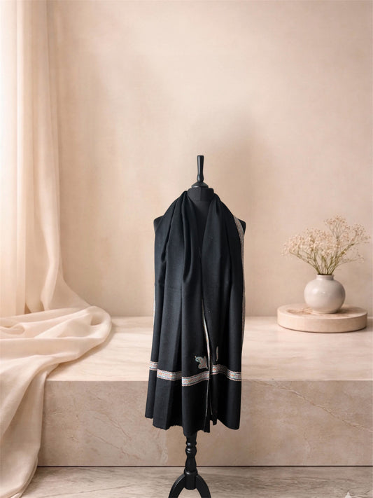 Black pashmina shawl with ivory and gold Sozni border worn over the shoulders, front view