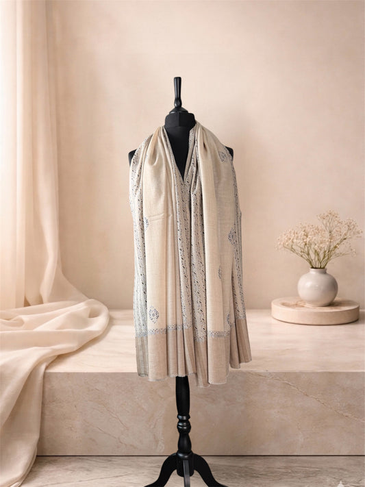 Ivory pashmina shawl with black embroidered stripes worn over the shoulders, front view