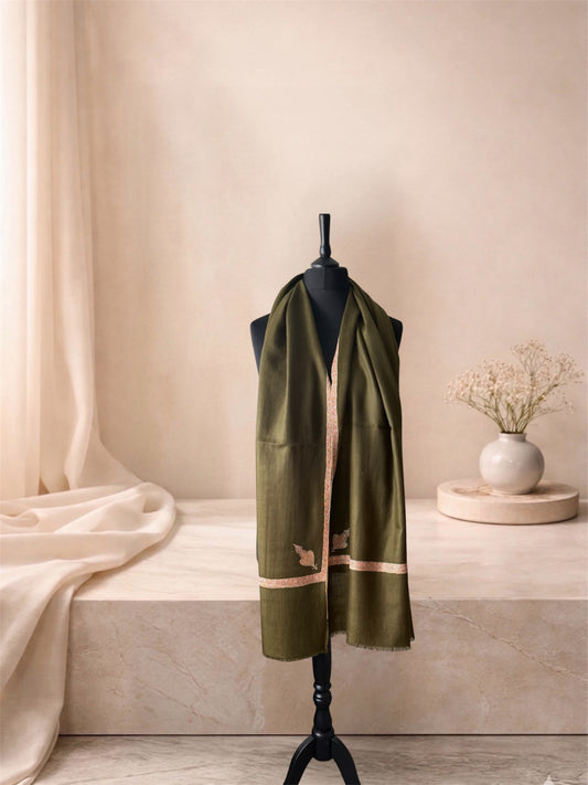 Moss green pashmina shawl with pink Sozni border and leaf motif worn over the shoulders, front view