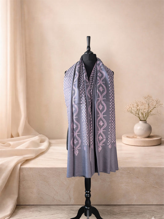 Storm grey pashmina shawl with all-over blush embroidery worn over the shoulders, front view
