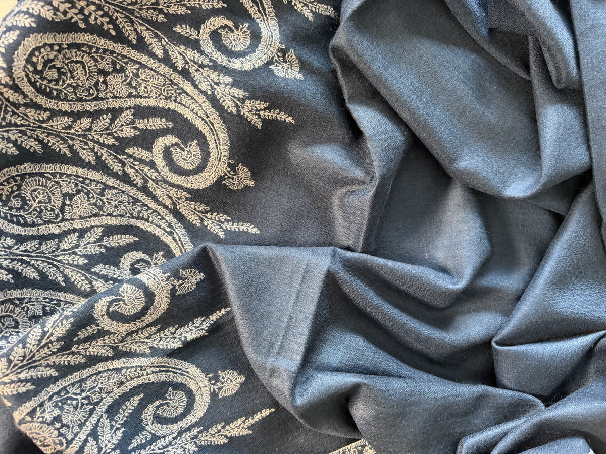 Close-up of ivory Sozni paisley embroidery on indigo blue pashmina