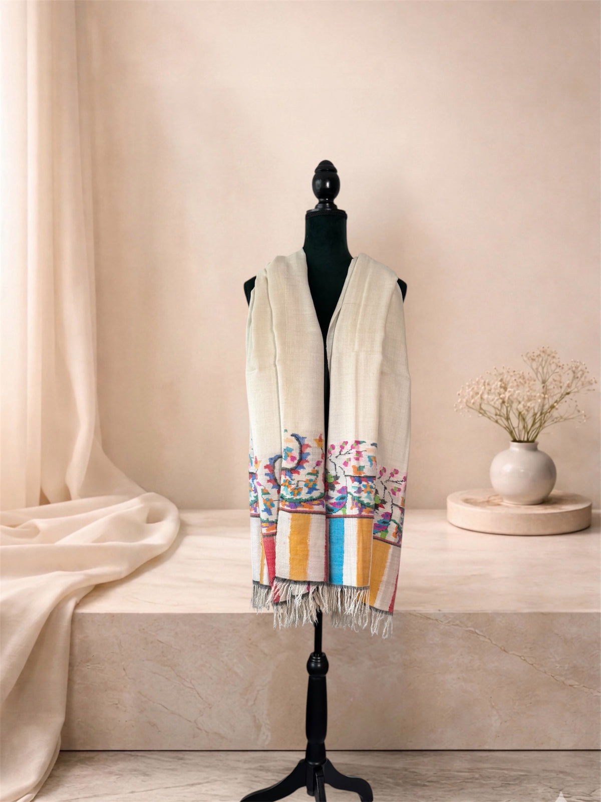 Ivory pashmina shawl with woven floral vine and striped ends worn over the shoulders, front view