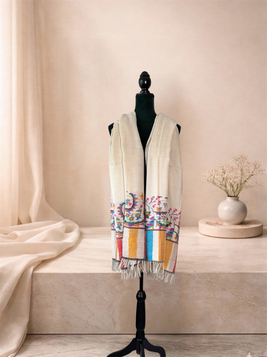 Ivory pashmina shawl with woven floral vine and striped ends worn over the shoulders, front view