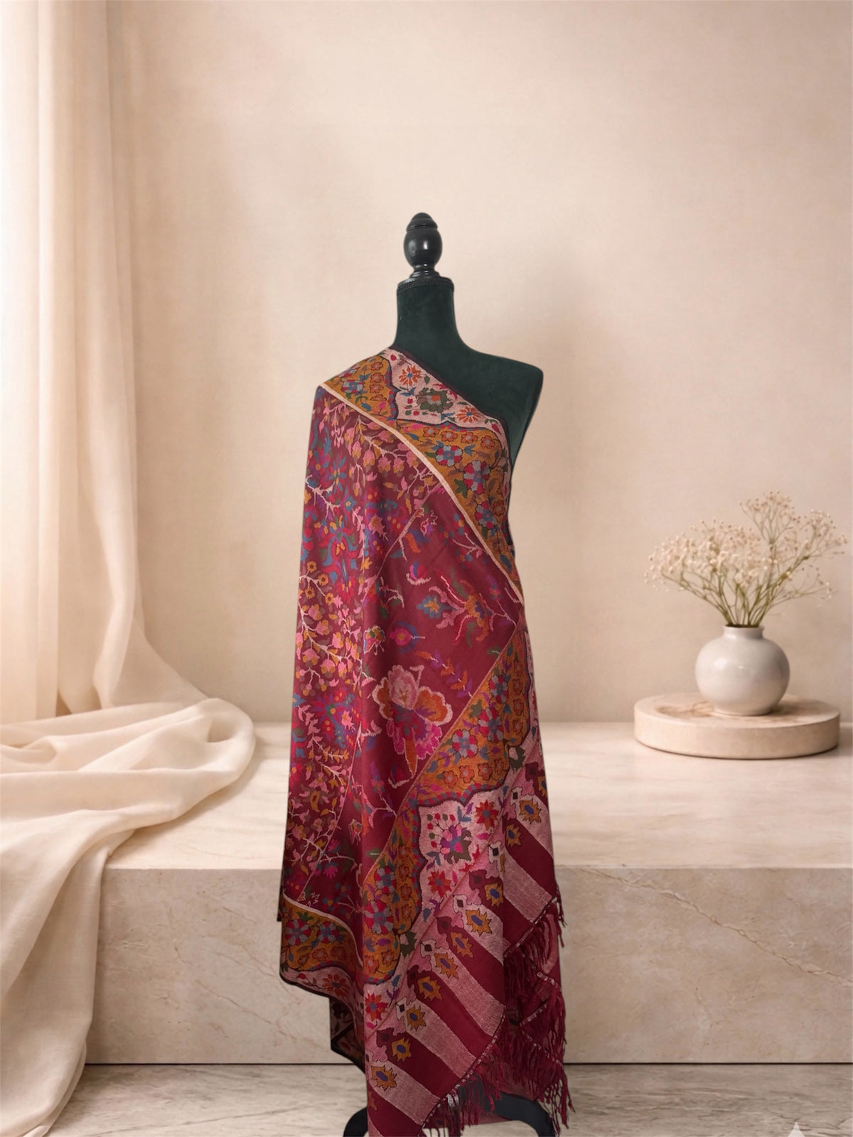 Wine red Kani pashmina shawl with ochre border draped on a mannequin, side view