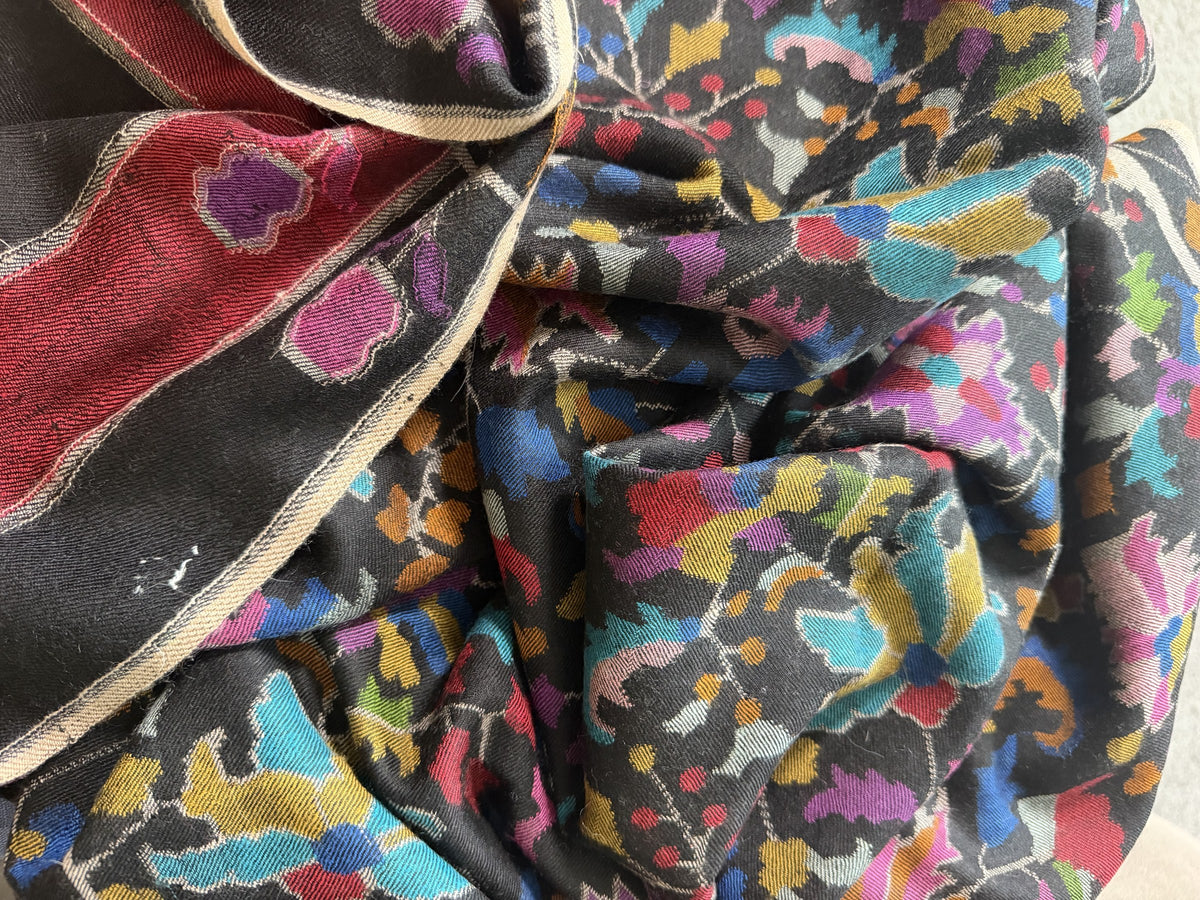 Close-up of turquoise, magenta and saffron Kani florals on black pashmina