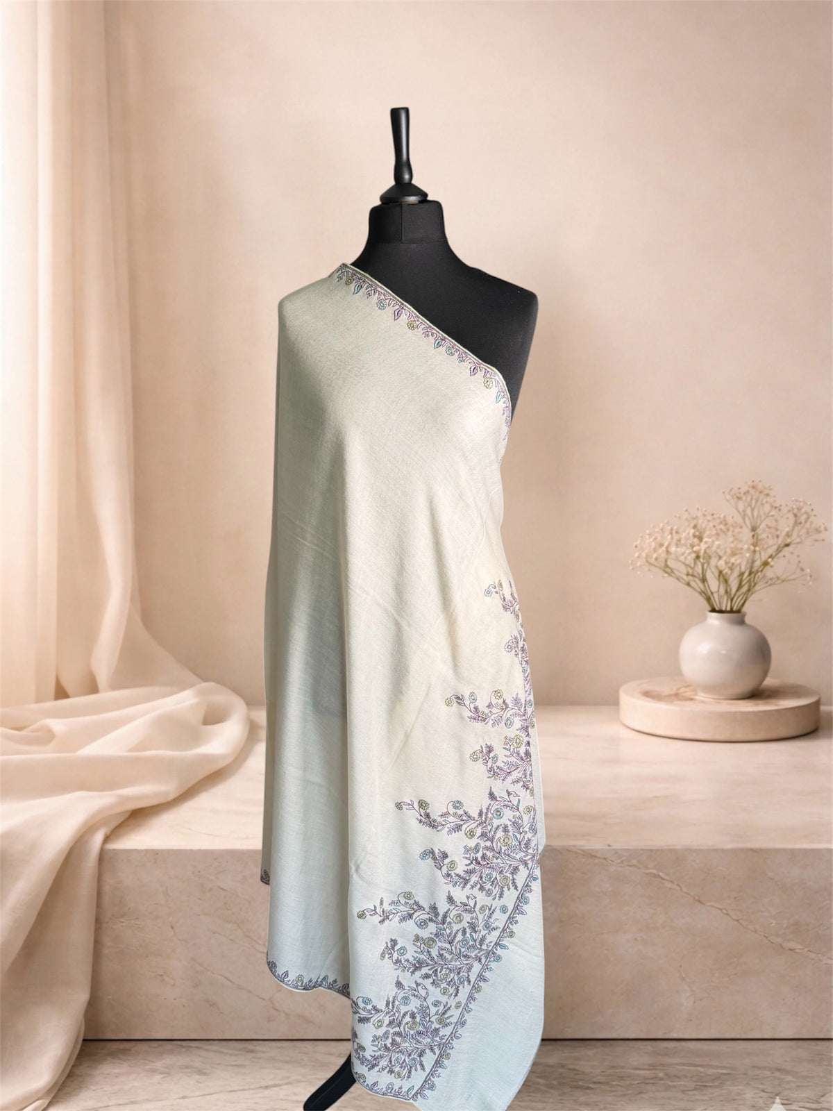 Ivory pashmina shawl with lilac Sozni floral vine embroidery draped on a mannequin, side view