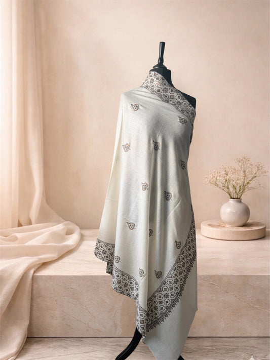Ivory pashmina shawl with black Sozni lattice border and buti draped on a mannequin, side view
