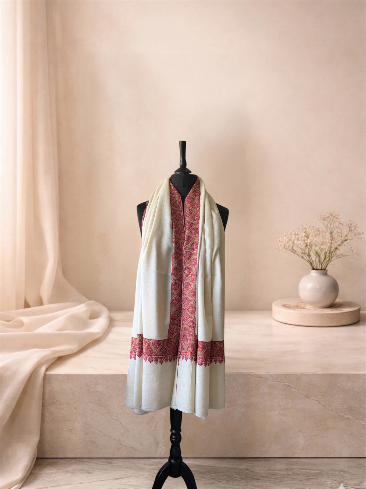 Ivory pashmina shawl with crimson border worn over the shoulders, front view