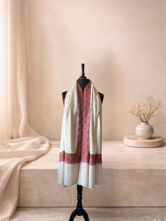 Ivory pashmina shawl with crimson border worn over the shoulders, front view