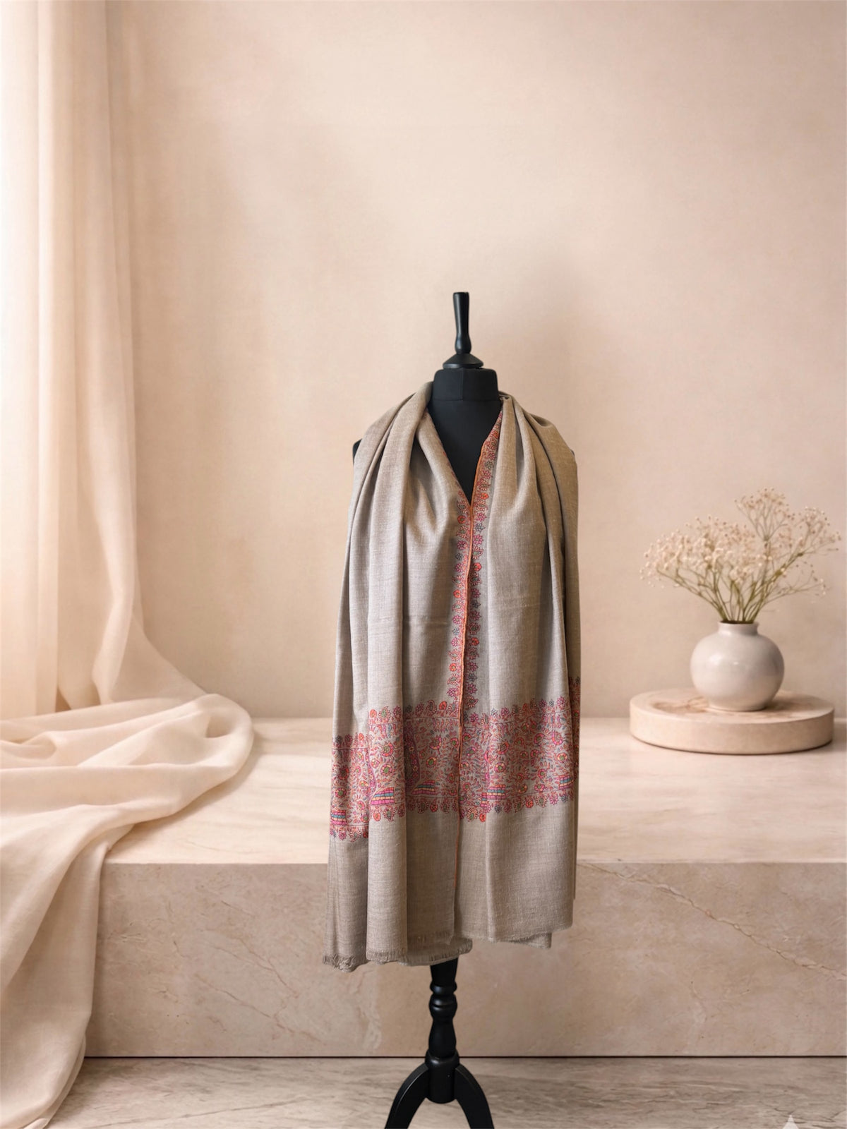Natural beige pashmina shawl with pink paisley end bands worn over the shoulders, front view