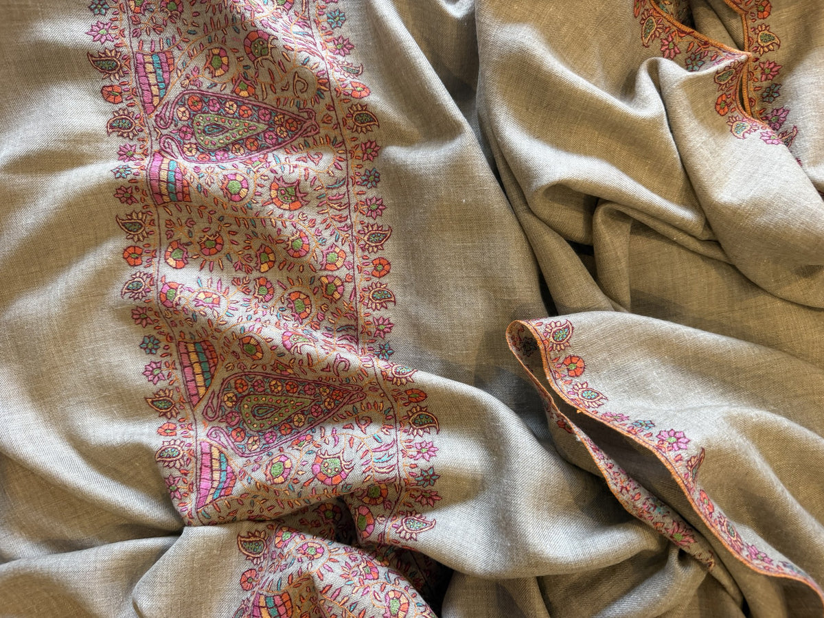 Close-up of pink and multicolour Sozni paisley border on natural beige pashmina