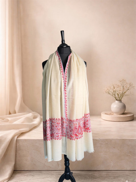 Ivory pashmina shawl with pink embroidered end bands worn over the shoulders, front view