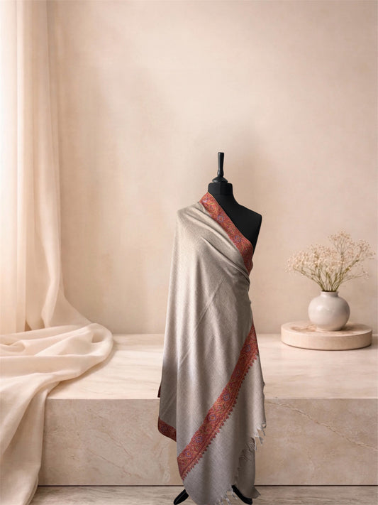 Natural beige pashmina shawl with red Sozni paisley border draped on a mannequin, side view