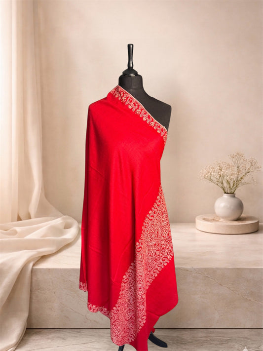 Red pashmina shawl with ivory Sozni paisley border draped on a mannequin, side view