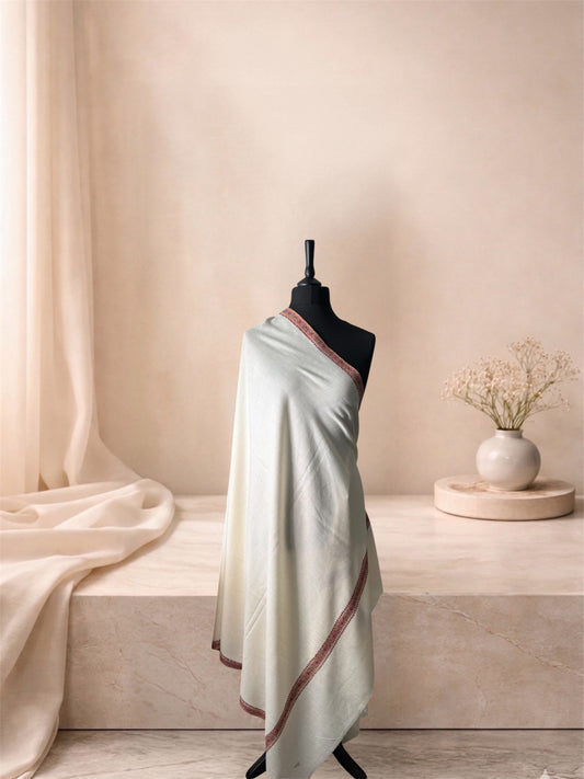 Ivory pashmina shawl with narrow maroon border draped on a mannequin, side view