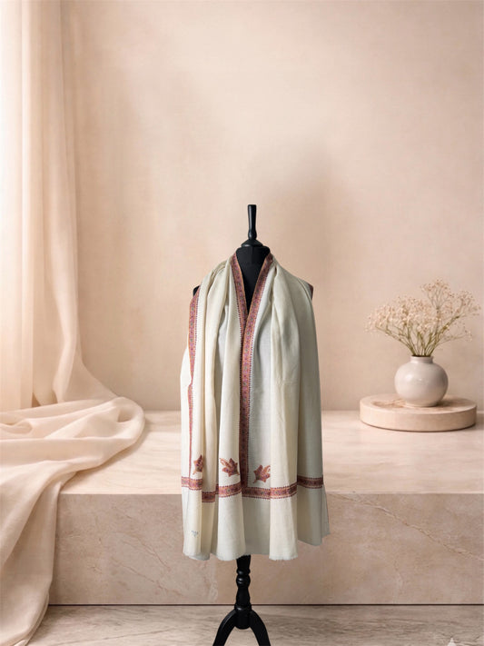 Ivory pashmina shawl with maroon Sozni border and leaf motifs worn over the shoulders, front view