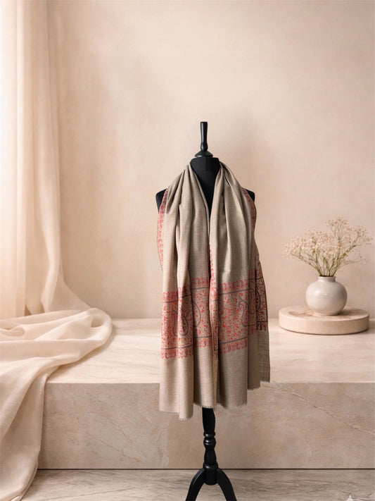 Natural beige pashmina shawl with coral paisley end panels worn over the shoulders, front view