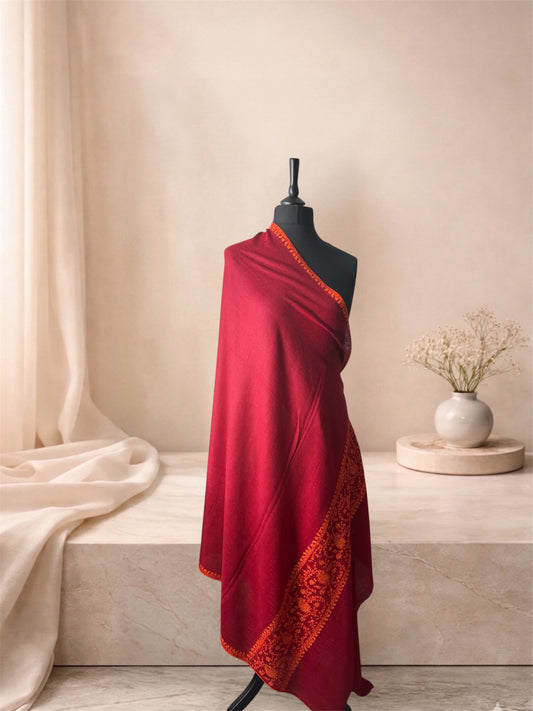 Crimson red pashmina shawl with orange Sozni border draped on a mannequin, side view