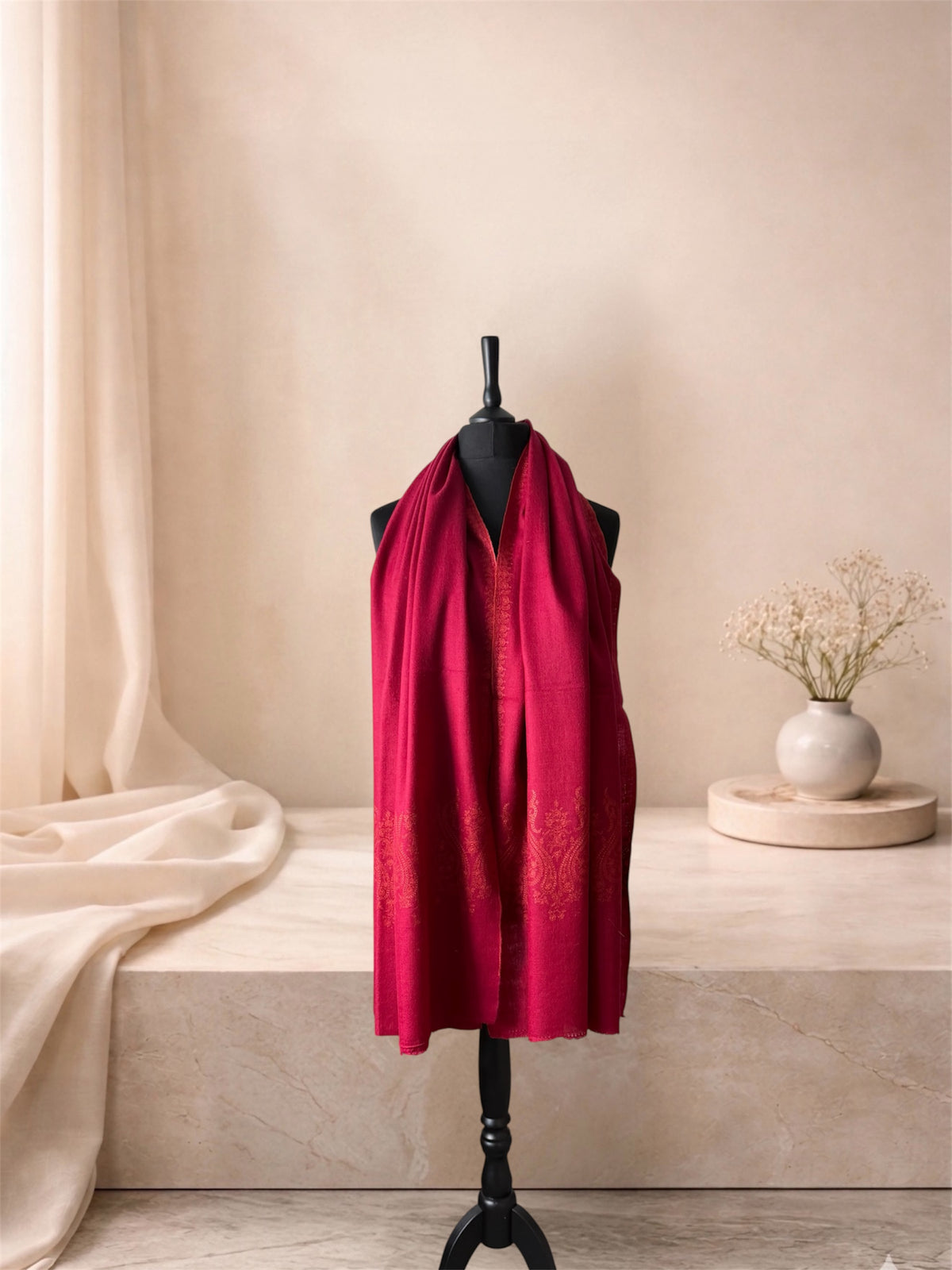 Raspberry red pashmina shawl with coral Sozni paisley ends worn over the shoulders, front view