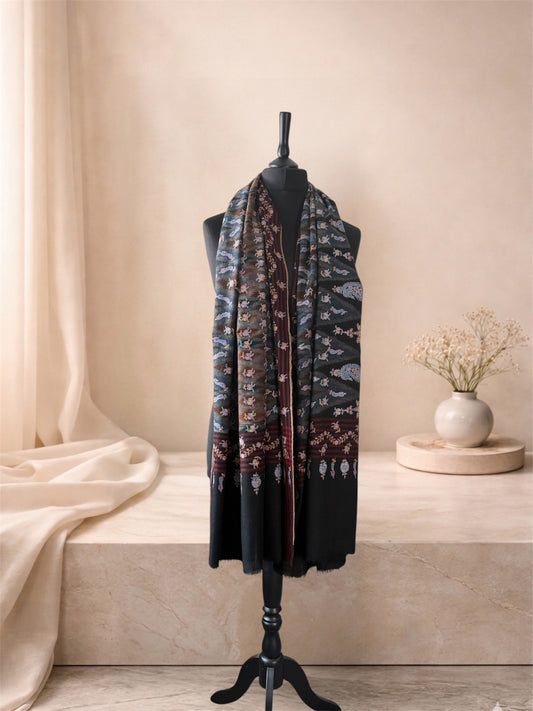 Black ikat pashmina shawl with multicolour embroidery worn over the shoulders, front view
