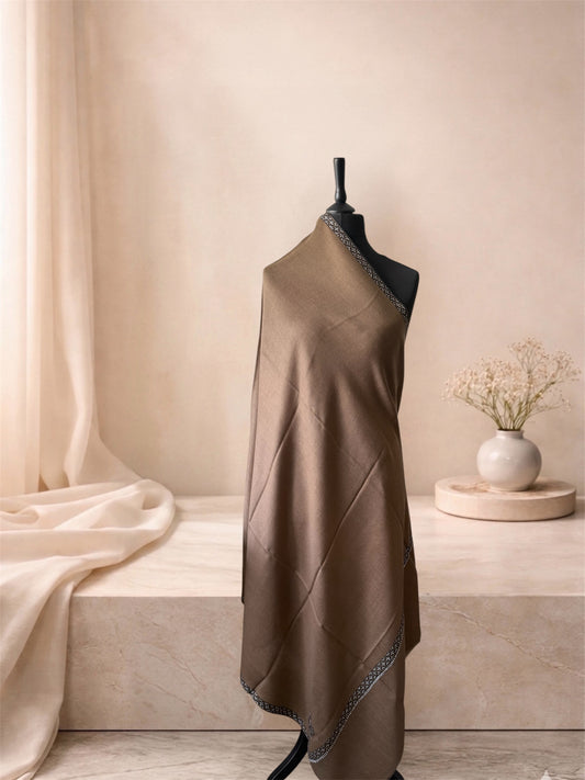 Camel brown pashmina shawl with narrow black and white border draped on a mannequin, side view