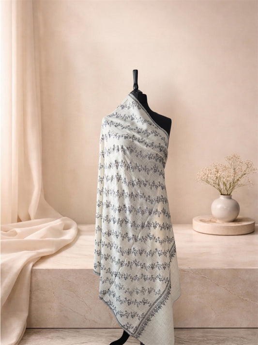 Ivory pashmina shawl with charcoal Sozni vine jaal draped on a mannequin, side view