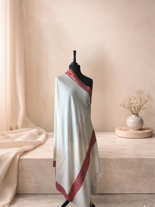 Ivory pashmina shawl with rose red Sozni border draped on a mannequin, side view
