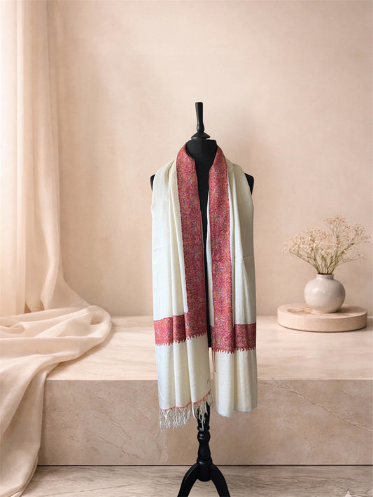 Ivory pashmina shawl with dense rose red border worn over the shoulders, front view