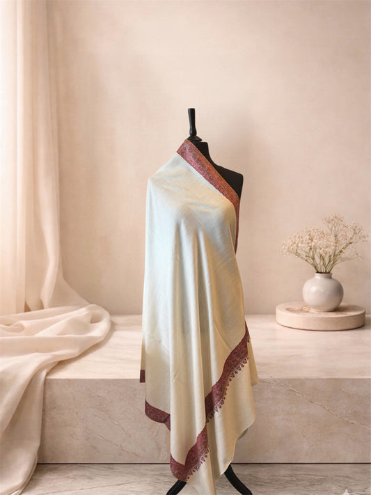 Ivory pashmina shawl with maroon Sozni border draped on a mannequin, side view
