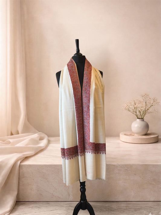 Ivory pashmina shawl with maroon border worn over the shoulders, front view