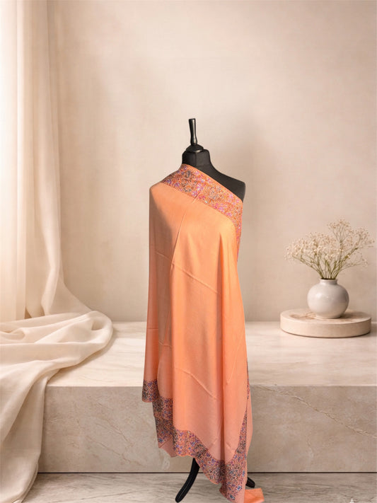 Peach pashmina shawl with multicolour Sozni border draped on a mannequin, side view