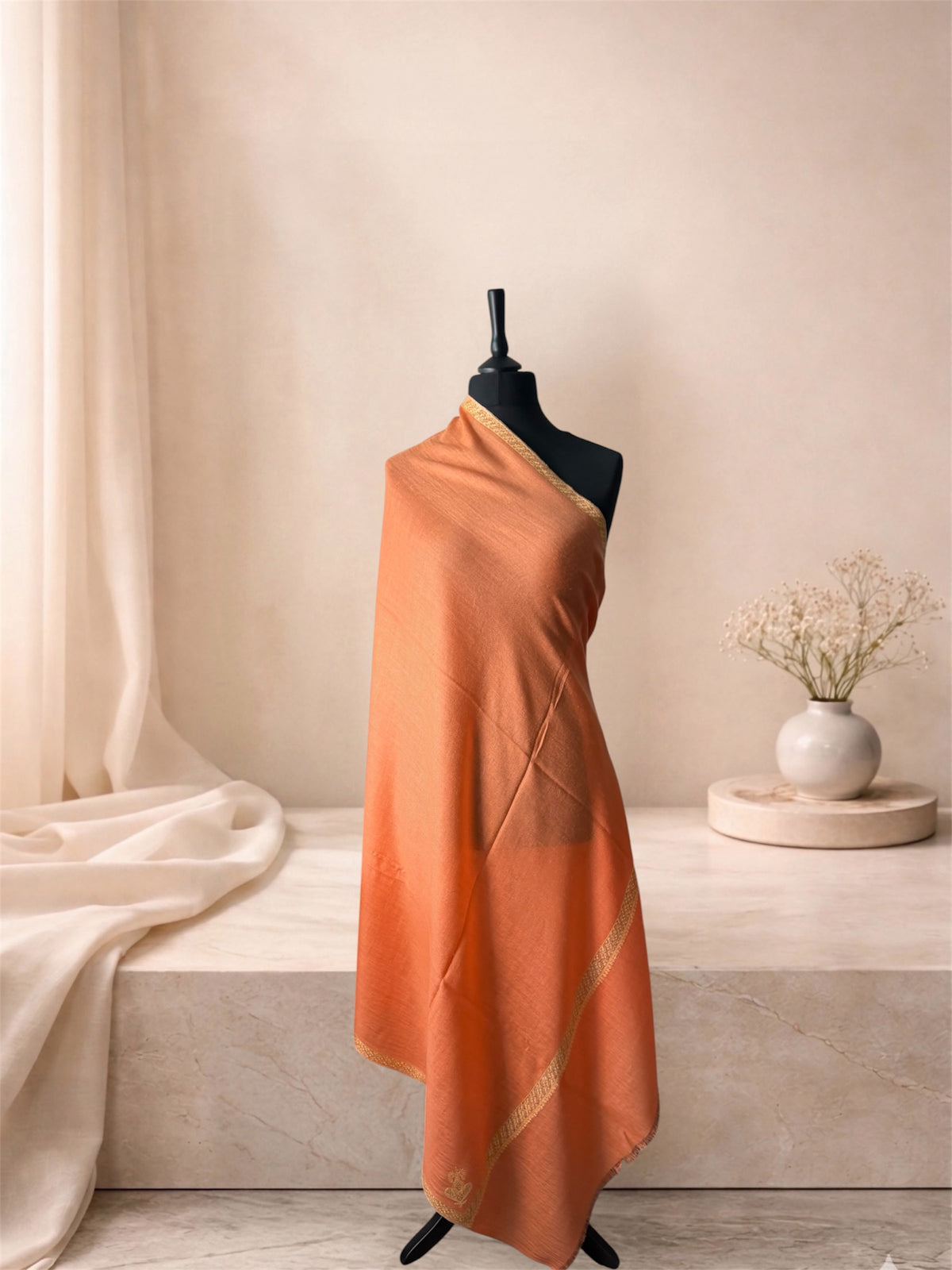 Burnt orange pashmina shawl with narrow gold border draped on a mannequin, side view