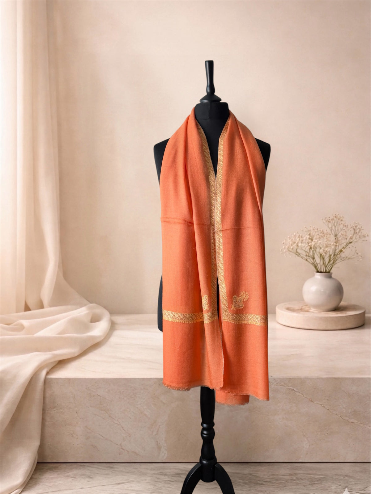 Burnt orange pashmina shawl with gold Sozni border worn over the shoulders, front view