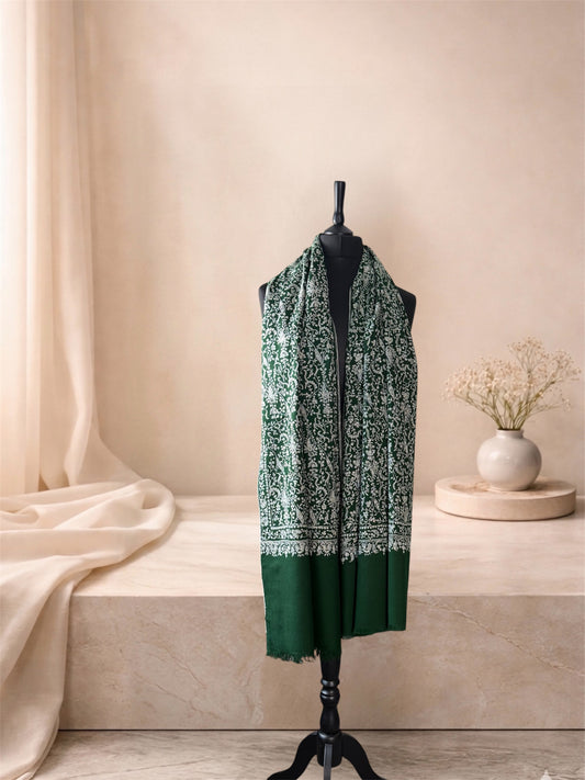 Bottle green pashmina shawl with ivory embroidery worn over the shoulders, front view