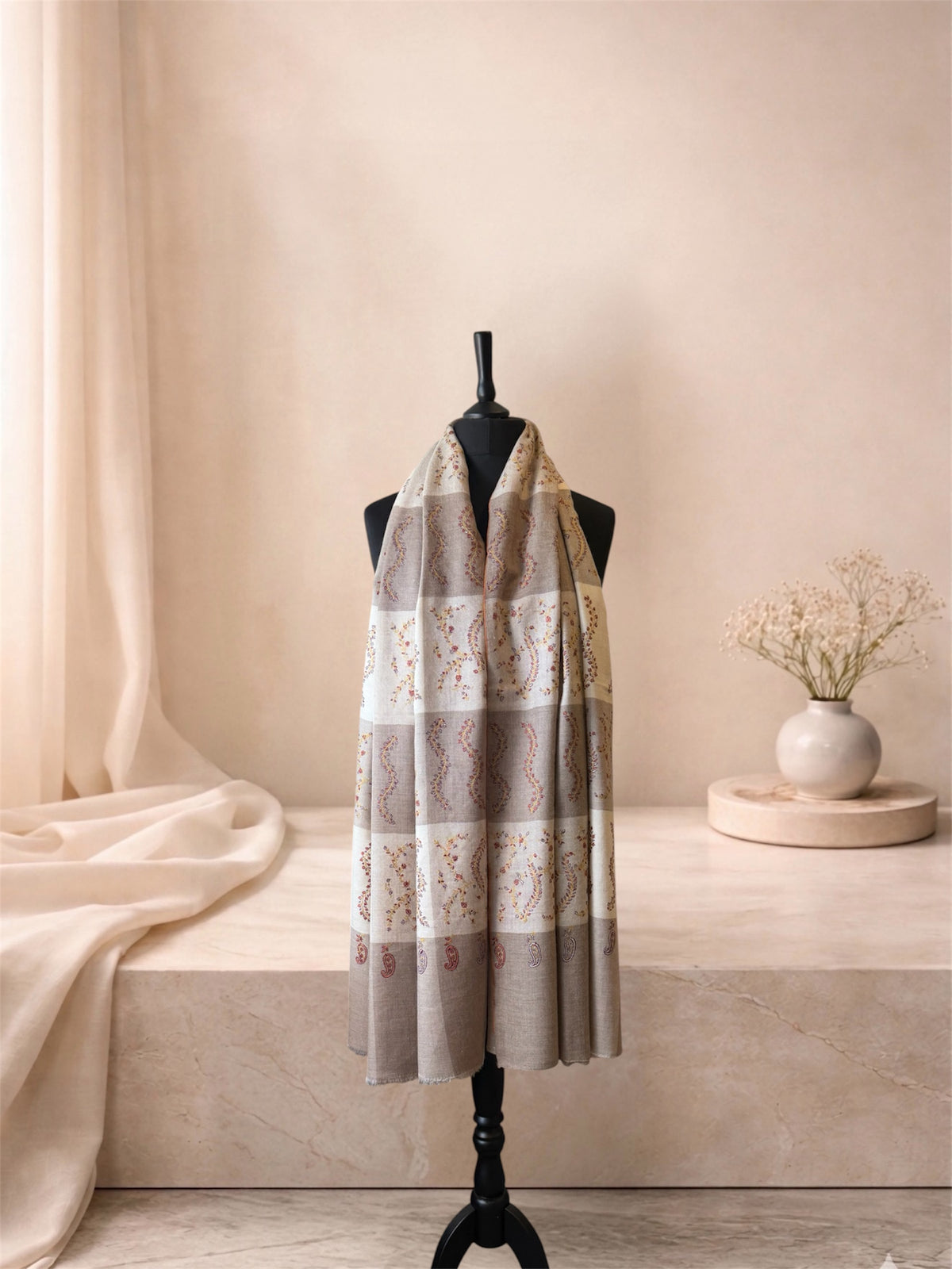 Taupe and ivory checked pashmina shawl worn over the shoulders, front view