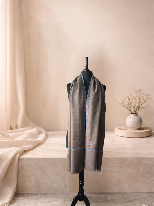 Two-sided striped pashmina shawl shown taupe side out, worn over the shoulders, front view