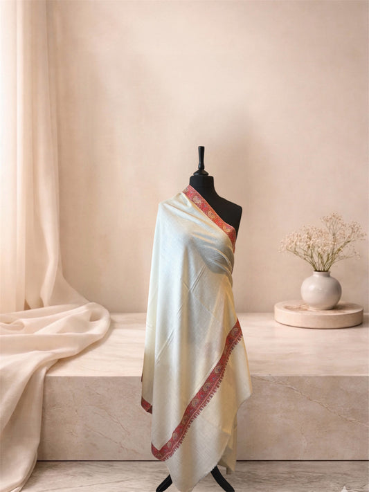 Ivory pashmina shawl with coral red floral border draped on a mannequin, side view