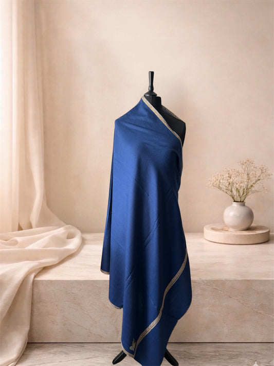 Denim blue pashmina shawl with narrow gold border draped on a mannequin, side view