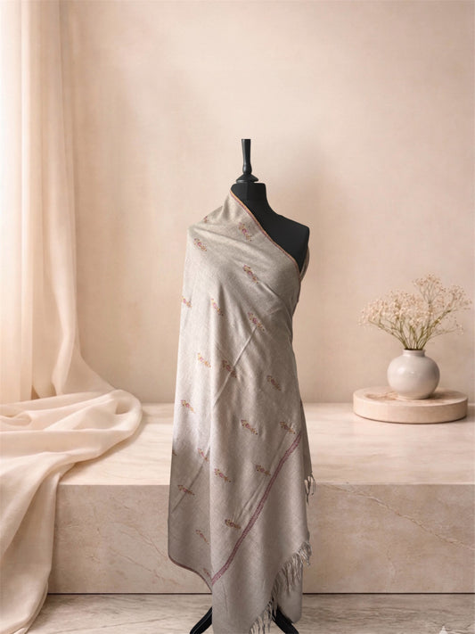 Natural beige pashmina shawl with scattered floral sprigs draped on a mannequin, side view