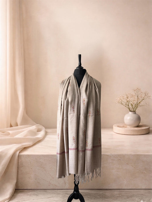 Natural beige pashmina shawl with fringed ends worn over the shoulders, front view
