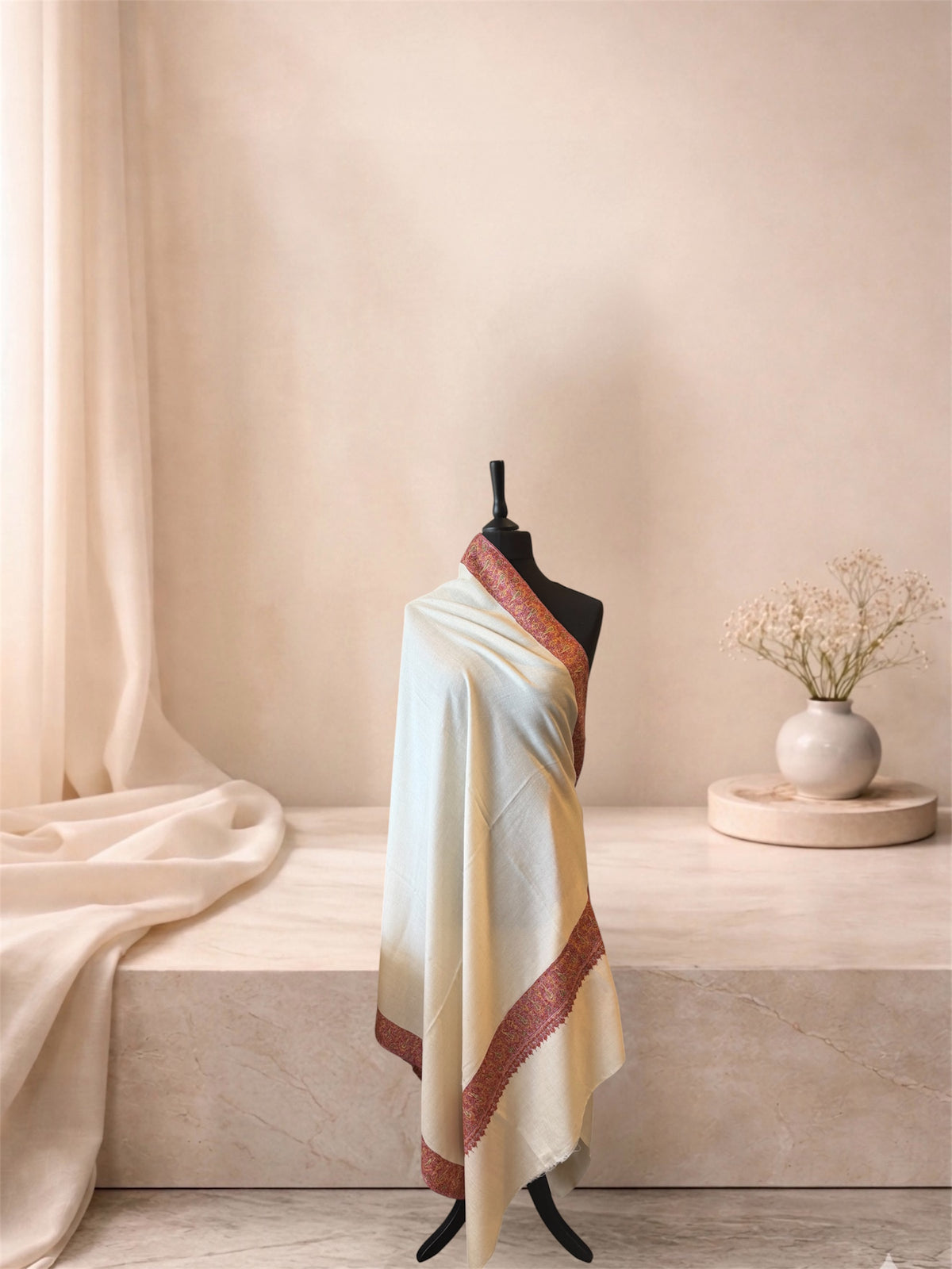 Ivory pashmina shawl with brick red Sozni paisley border draped on a mannequin, side view