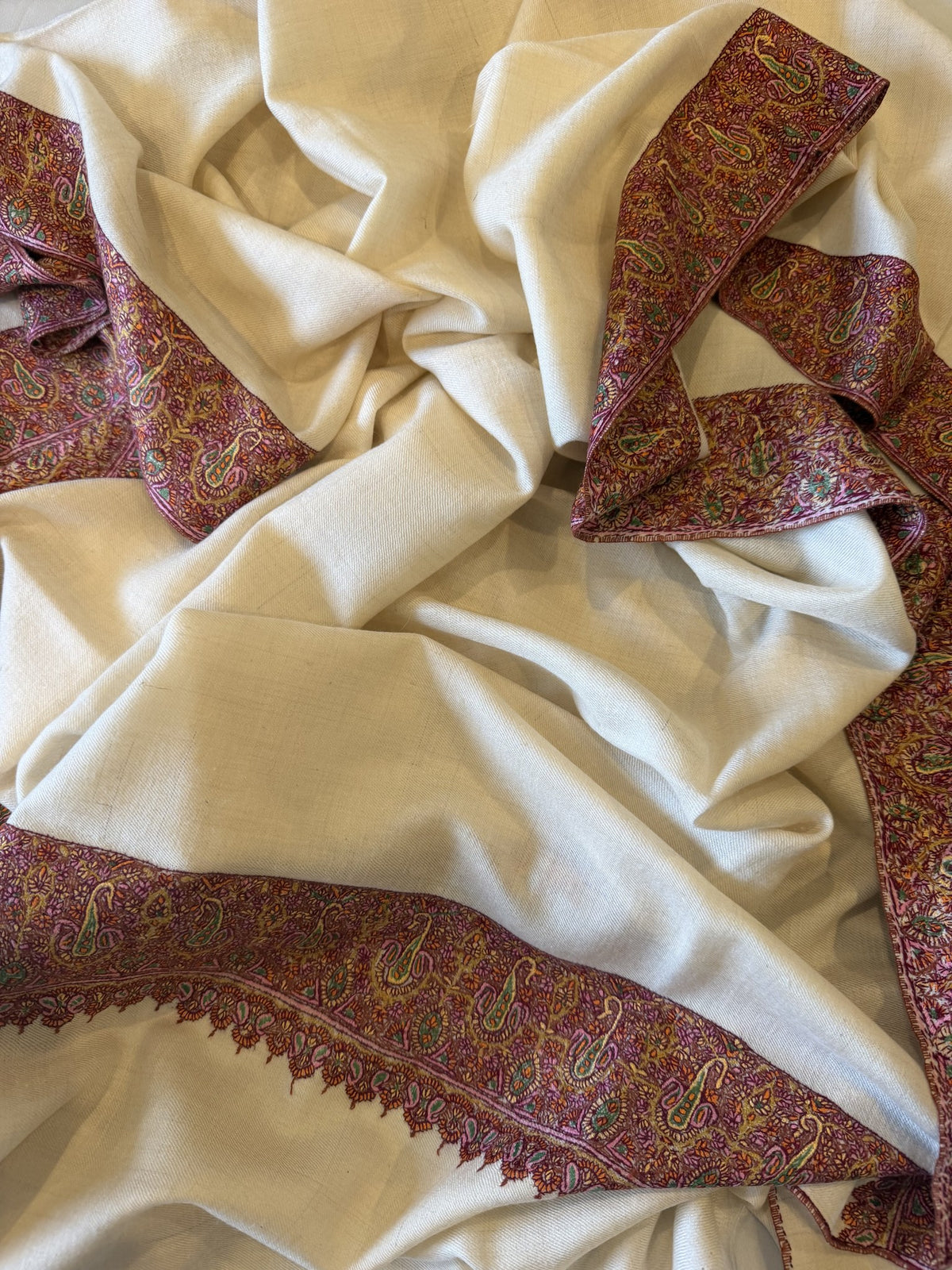 Close-up of brick red and gold Sozni paisley border on ivory pashmina