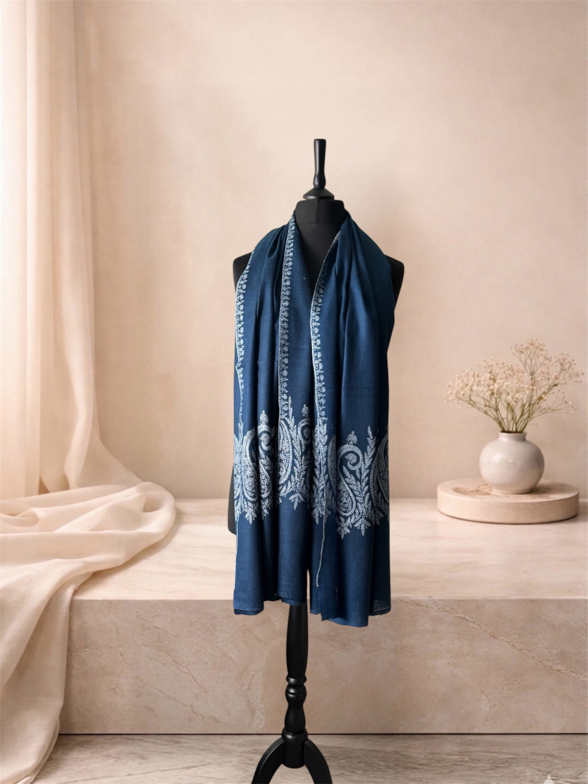 Indigo blue pashmina shawl with ivory paisley ends worn over the shoulders, front view