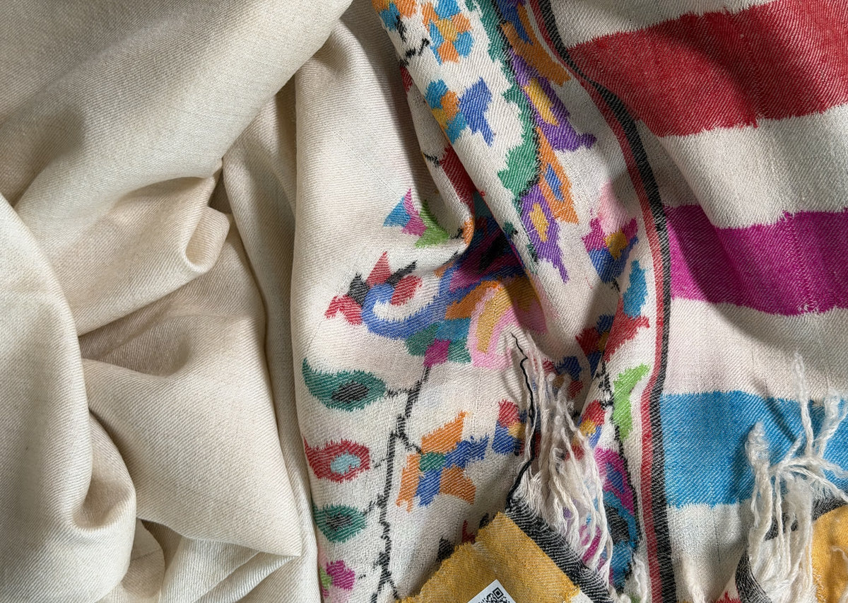 Close-up of Kani floral vine and saffron, blue and magenta stripes on ivory pashmina