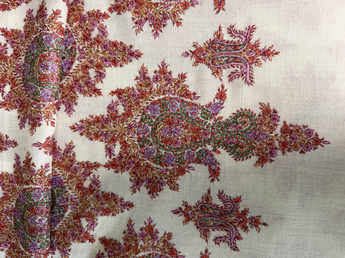 Close-up of a large rust red Sozni paisley spray on ivory pashmina