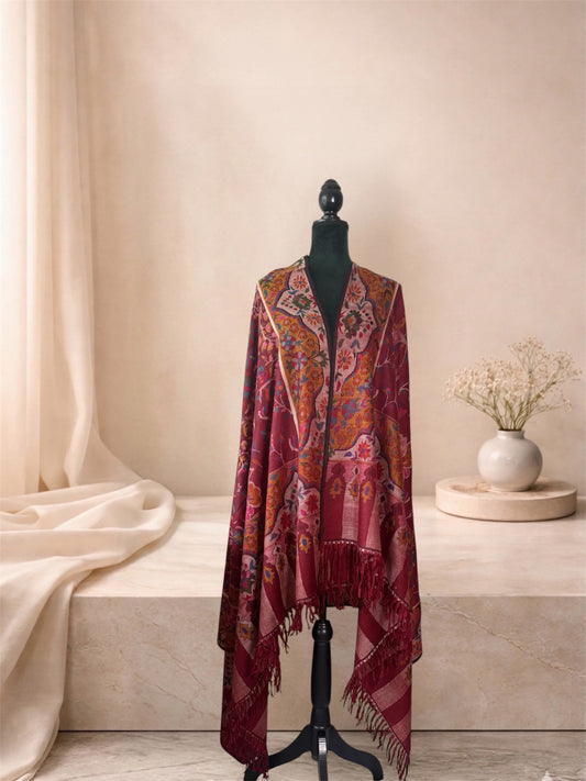 Wine red Kani pashmina shawl with fringed striped ends worn over the shoulders, front view