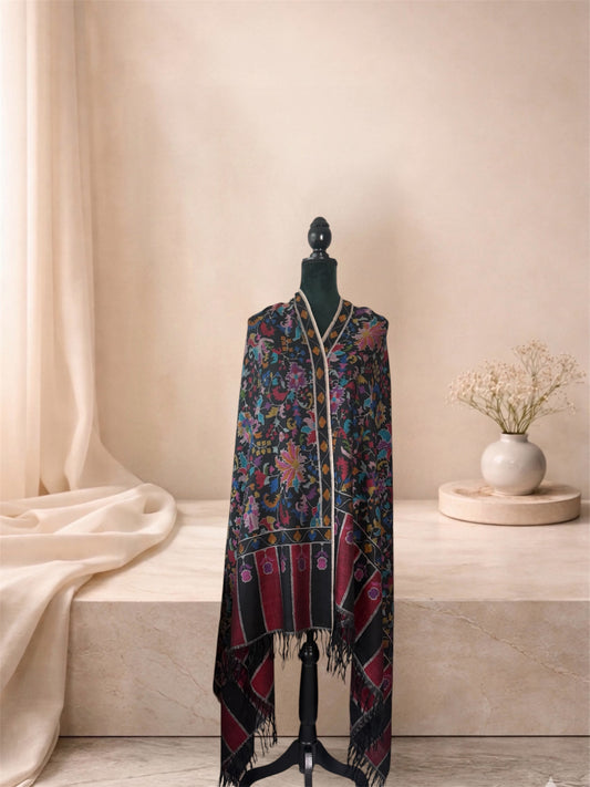 Black Kani pashmina shawl with striped crimson ends worn over the shoulders, front view